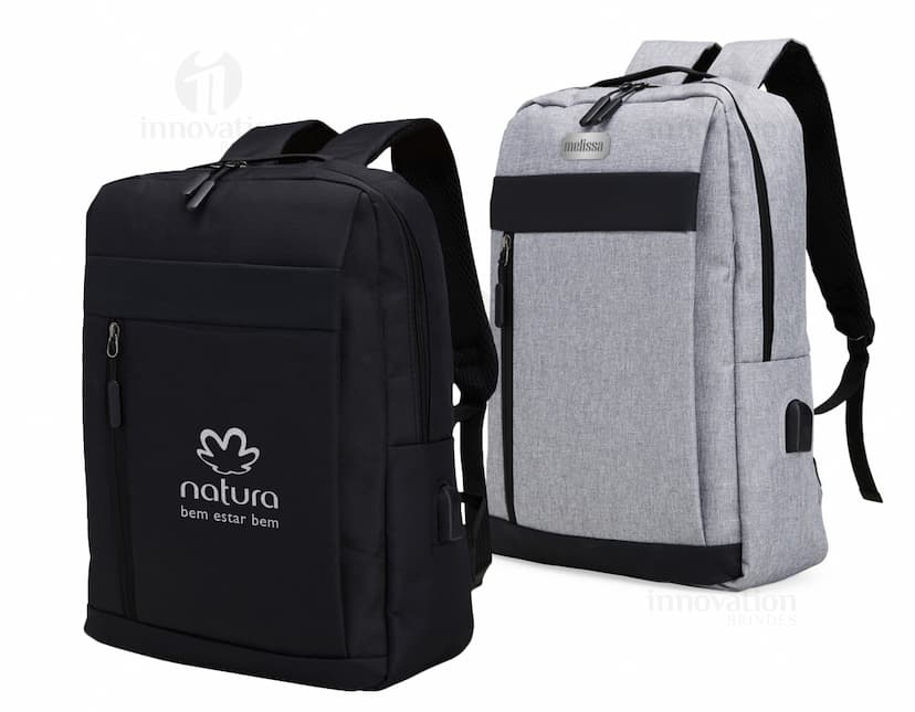 Mochila de nylon preta com capacidade de 21 litros, com detalhes em couro. Possui compartimento para USB, alças, zíper, etiqueta com logotipo e bolso frontal. Ideal para viagens e uso diário, estilo moderno e elegante.