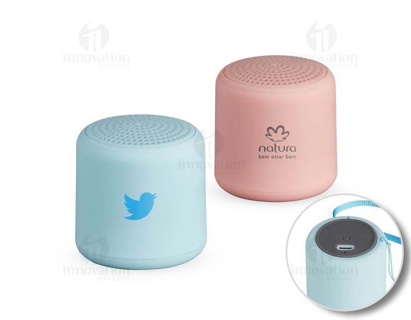 Caixa de som Bluetooth preta e prateada, com design moderno e compacto. Feita de material metálico e plástico, possui botões de controle, entrada USB e conexão sem fio. Ideal para uso em escritórios, em casa ou em ambientes corporativos.