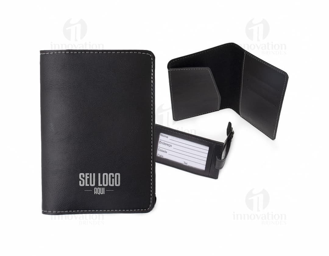 Carteira de viagem em couro marrom e porta-documentos preto abertos, contendo notas, cartões e moedas, ao lado de um notebook e um teclado eletrônico.