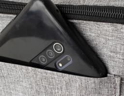 Bolsa térmica de 9L em couro marrom com detalhes em metal, fecho de zíper, alça e bolso externo. Textura elegante e moderna