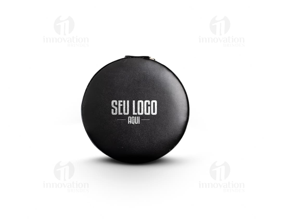 Um porta joias de metal prateado, com tampa de vidro circular e lente de aumento embutida. O objeto possui um design