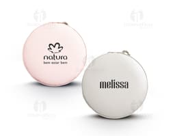 Um porta joias de metal prateado, com tampa de vidro circular e lente de aumento embutida. O objeto possui um design