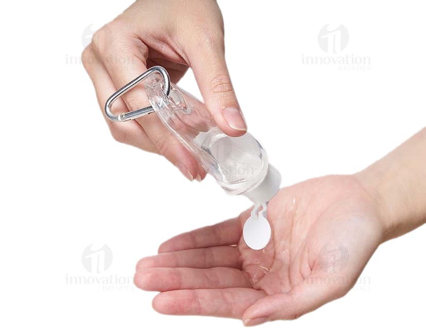 Frasco plástico 55ml com mosquetão sendo segurado por uma mão masculina, em um ambiente de escritório. A imagem mostra detalhes do frasco, como sua tampa e seu tamanho compacto, ideal para transporte.
