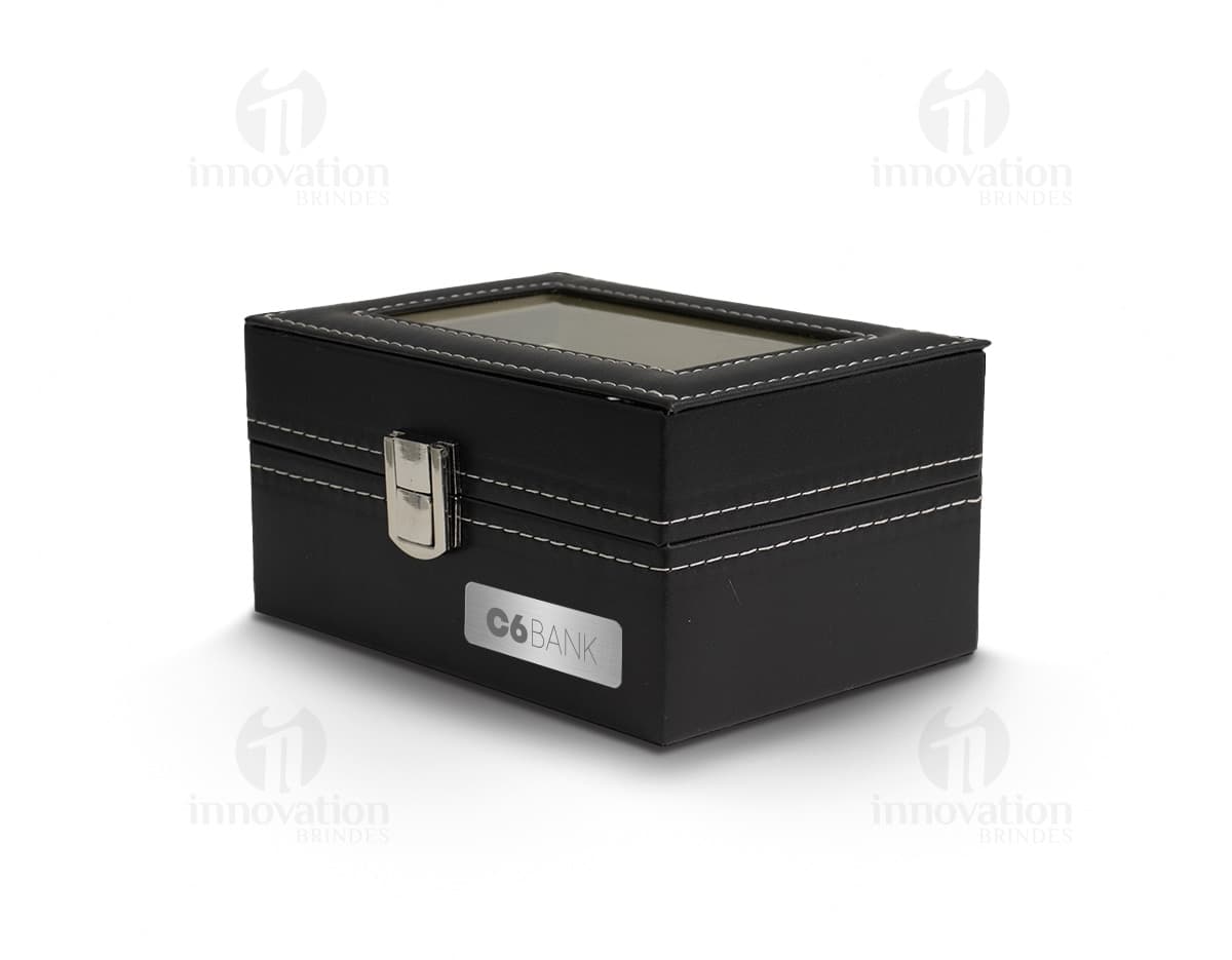 Caixa de couro preta contendo relógios, equipamento de gravação, dinheiro e objetos de valor.