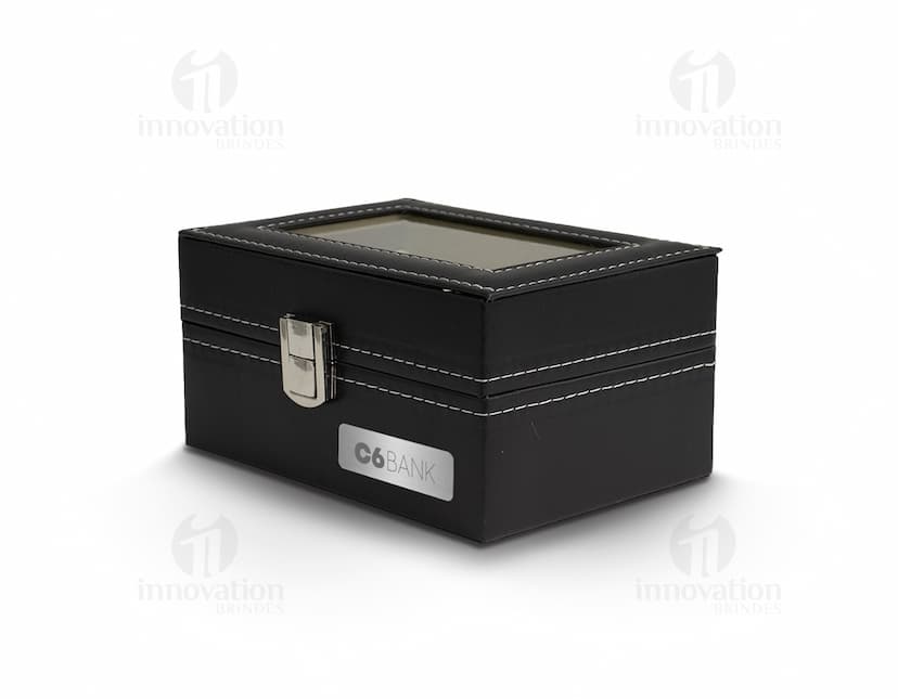 Caixa de couro preta contendo relógios, equipamento de gravação, dinheiro e objetos de valor.