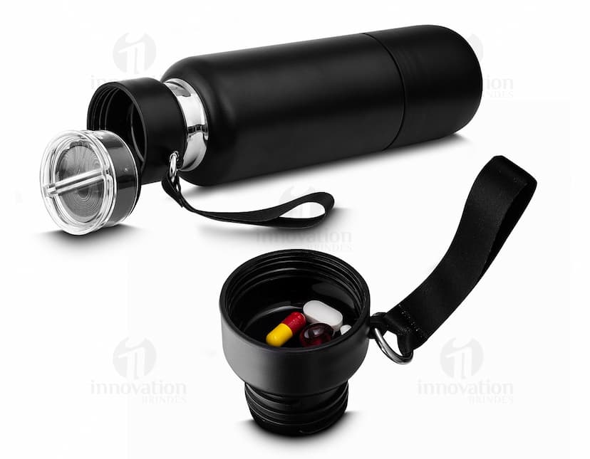 Garrafa térmica inox com mosquetão em ambiente escuro, próximo a um dispositivo eletrônico, fio, lâmpada e alto-falante.