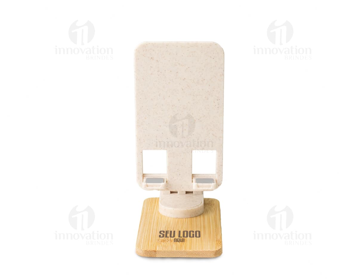 Suporte retrátil para celular 360° em papel marrom vazio, com textura antiga e desgastada. O suporte é amarelo com detalhes em madeira e metal, oferecendo um design vintage e grunge. O objeto está em cima de um bloco de madeira velho, em um espaço de escritório desorganizado.