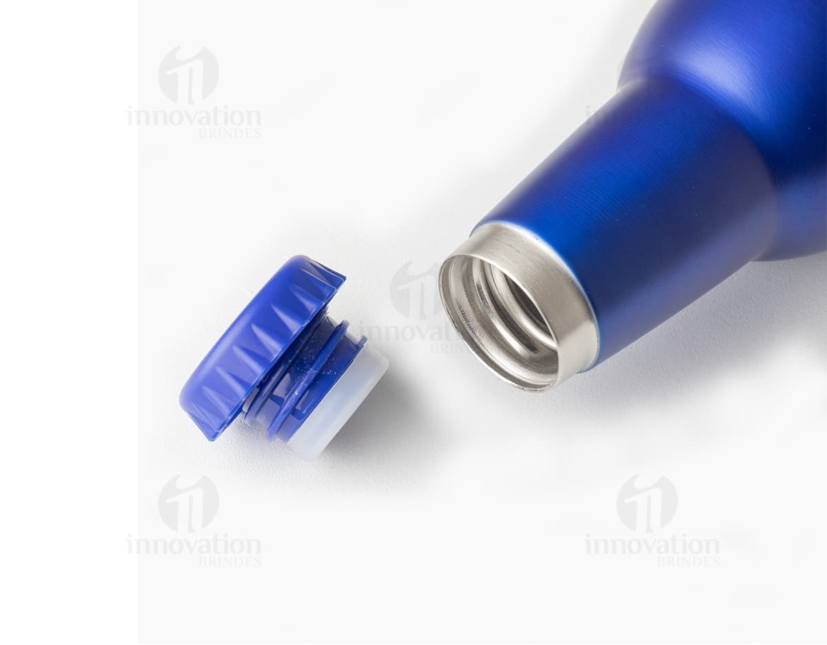 Garrafa de inox de 350ml, com rótulo, completamente cheia de líquido transparente. A garrafa está sobre uma mesa com outras garrafas e copos de bebida ao redor. O ambiente parece ser um bar ou restaurante. A garrafa tem um design elegante e clean, com tampa de rolha.