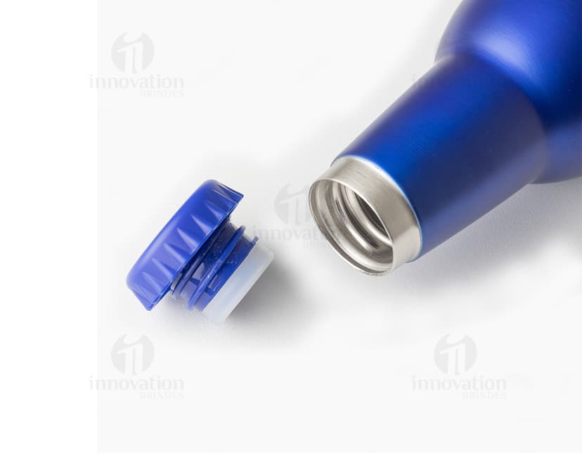 Garrafa de inox de 350ml, com rótulo, completamente cheia de líquido transparente. A garrafa está sobre uma mesa com outras garrafas e copos de bebida ao redor. O ambiente parece ser um bar ou restaurante. A garrafa tem um design elegante e clean, com tampa de rolha.