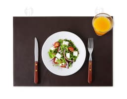 Lugar americano de couro sintético em uma mesa de jantar com diversos pratos coloridos e saudáveis, incluindo vegetais