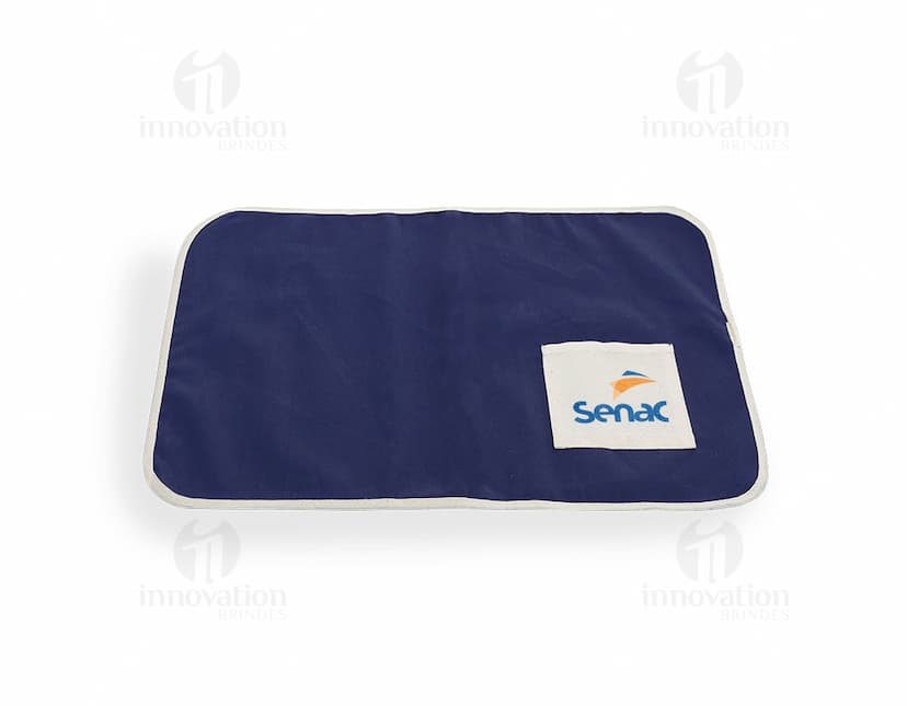 Sleeping bag de mesa de algodão com bolso em fundo rosa claro. A imagem mostra o produto aberto dentro de uma embalagem de plástico transparente com detalhes de textura em tecido de algodão preto. O produto parece novo e vazio, com espaço para colocar dinheiro, cartões de crédito, documentos e outros objetos pessoais. Ideal para uso no escritório, negócios ou para proteção de pertences pessoais.