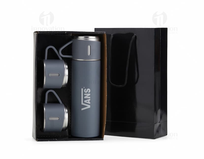 Kit garrafa térmica 450ml c/ sacola em formato 3D, moderno e prático. Garrafa térmica em metal prateado com design elegante, acompanhada de uma sacola preta para transporte. Ideal para manter a temperatura de bebidas por mais tempo, seja no escritório, em viagens ou no dia a dia.