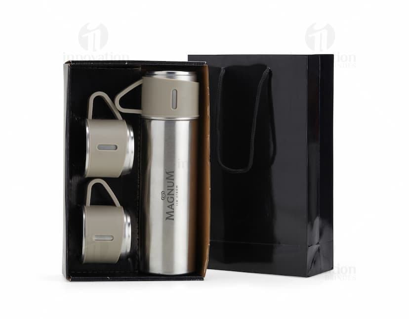 Kit garrafa térmica 450ml c/ sacola em formato 3D, moderno e prático. Garrafa térmica em metal prateado com design elegante, acompanhada de uma sacola preta para transporte. Ideal para manter a temperatura de bebidas por mais tempo, seja no escritório, em viagens ou no dia a dia.