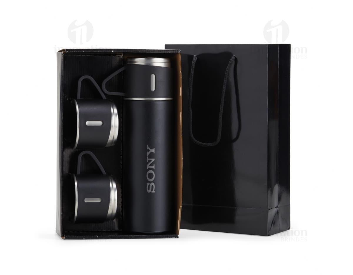 Kit garrafa térmica 450ml c/ sacola em formato 3D, moderno e prático. Garrafa térmica em metal prateado com design elegante, acompanhada de uma sacola preta para transporte. Ideal para manter a temperatura de bebidas por mais tempo, seja no escritório, em viagens ou no dia a dia.