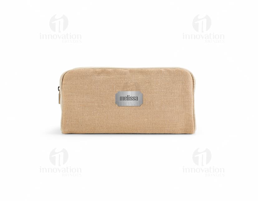 Bolsa de cosméticos marrom e preta, vazia, com fecho de zíper. Ao redor, encontram-se diversos objetos como um carimbo, um dado, uma ferramenta de modelagem, um apontador de lápis, um teclado de computador e uma chave. Há também notas de dinheiro, um cartão de crédito e um saco de compras.