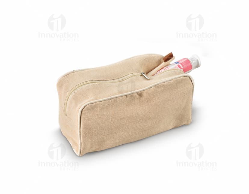 Bolsa de cosméticos marrom e preta, vazia, com fecho de zíper. Ao redor, encontram-se diversos objetos como um carimbo, um dado, uma ferramenta de modelagem, um apontador de lápis, um teclado de computador e uma chave. Há também notas de dinheiro, um cartão de crédito e um saco de compras.