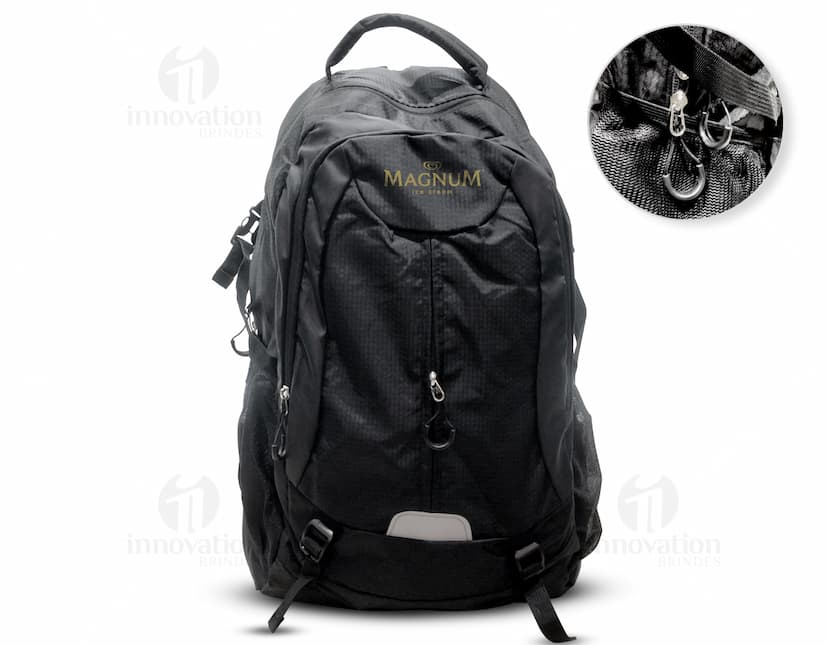 Homem usando mochila de nylon 43 litros em um estúdio. Ele está sorrindo e parece confiante, vestindo um terno preto e uma jaqueta de couro.