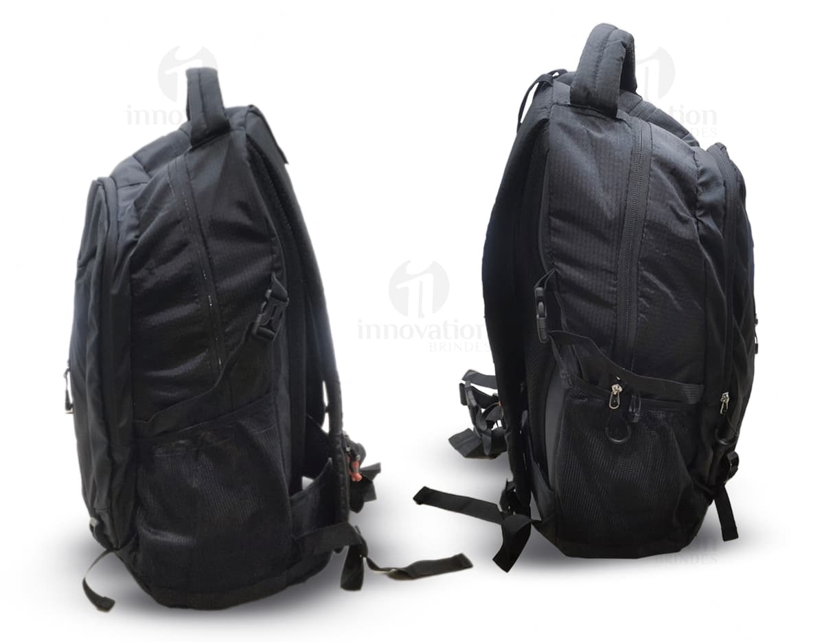 Homem usando mochila de nylon 43 litros em um estúdio. Ele está sorrindo e parece confiante, vestindo um terno preto e uma jaqueta de couro.