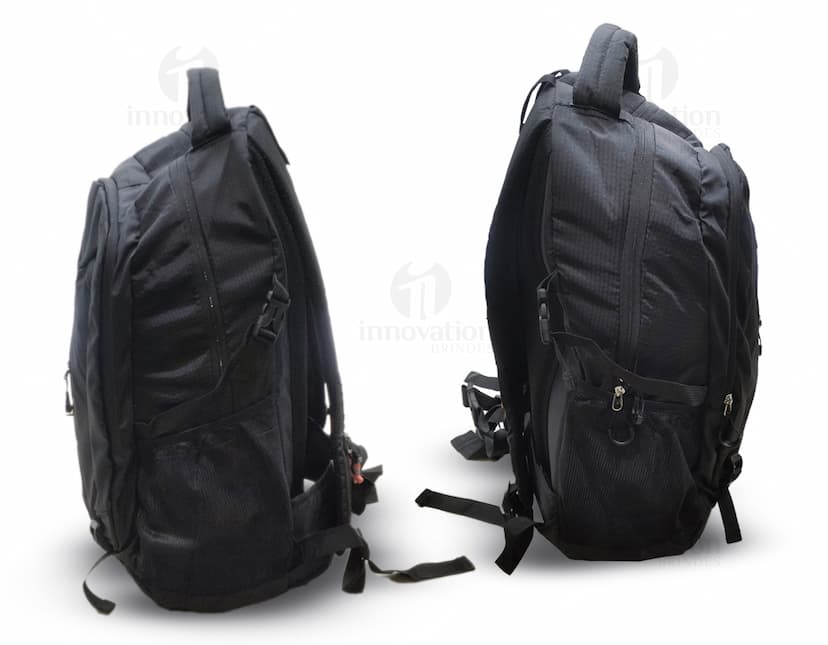Homem usando mochila de nylon 43 litros em um estúdio. Ele está sorrindo e parece confiante, vestindo um terno preto e uma jaqueta de couro.
