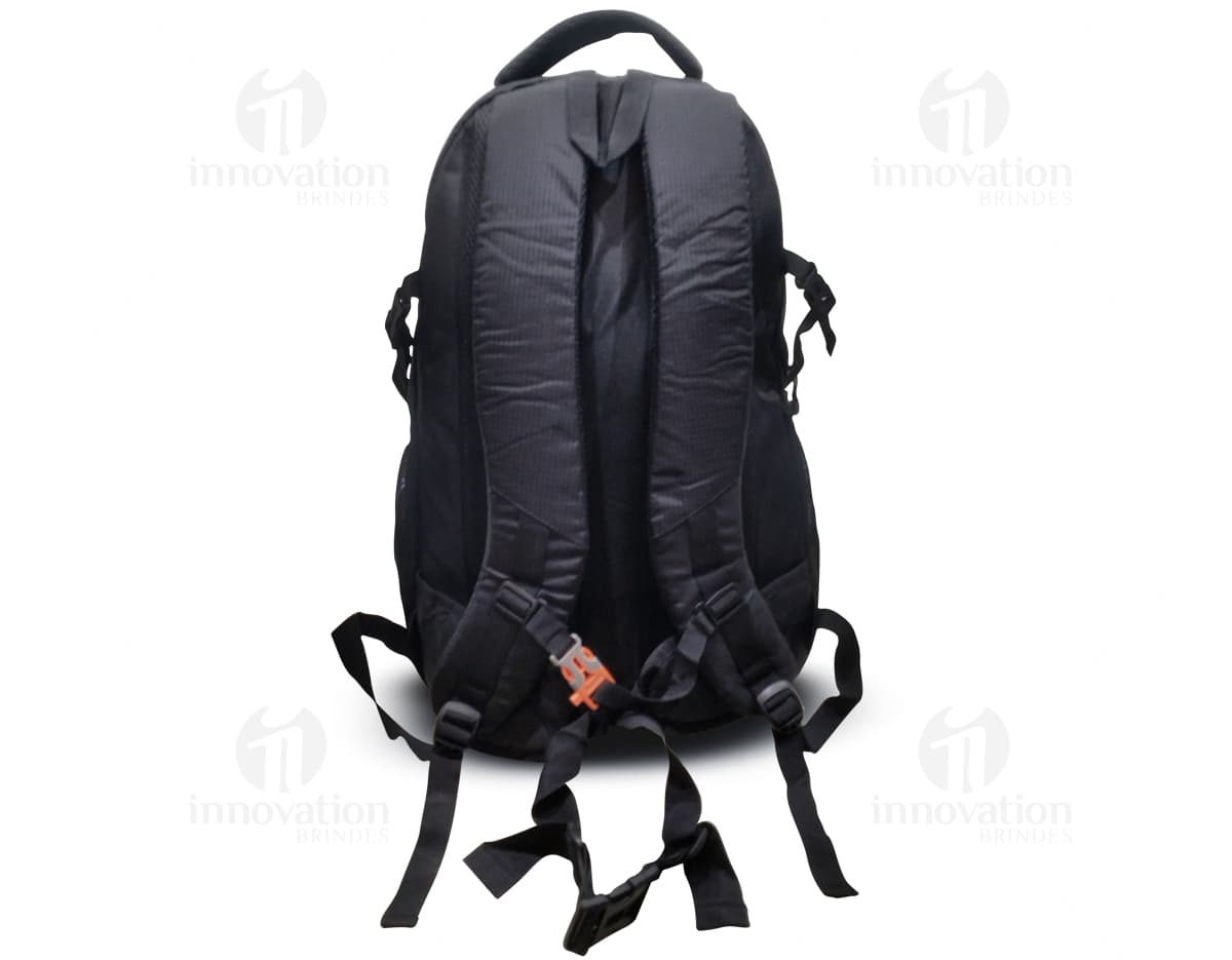 Homem usando mochila de nylon 43 litros em um estúdio. Ele está sorrindo e parece confiante, vestindo um terno preto e uma jaqueta de couro.