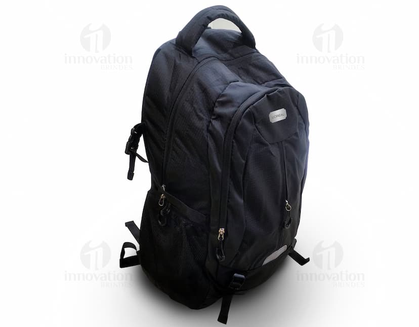 Homem usando mochila de nylon 43 litros em um estúdio. Ele está sorrindo e parece confiante, vestindo um terno preto e uma jaqueta de couro.