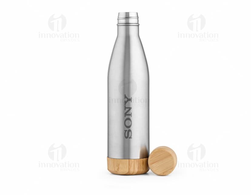 Garrafa em aço inox contendo líquido. A garrafa está vazia e possui rótulo. Está em um ambiente de celebração, com outros objetos de bar ao redor. A garrafa é transparente e reflete a luz, mostrando brilho.