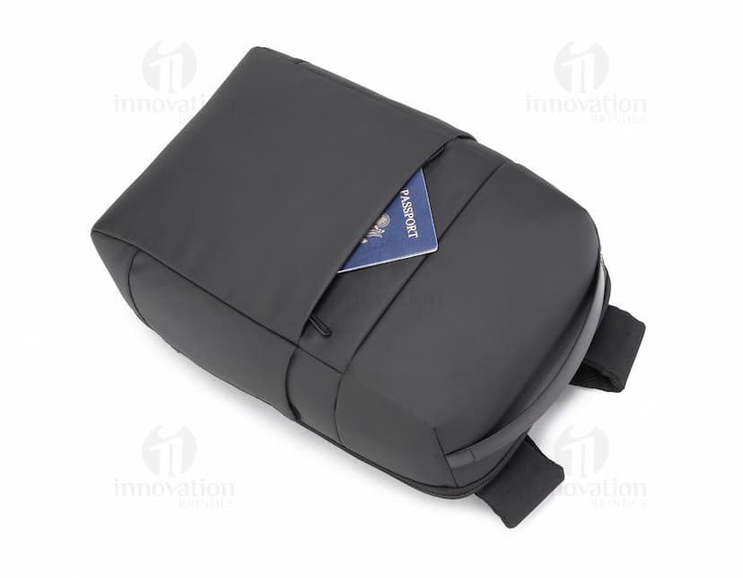 Mochila para Notebook Premium em tom preto, com design moderno e fecho de botão. Feita de couro sintético, possui compartimento para dispositivo eletrônico, conexões para cabos e adaptadores. Ideal para armazenar computador, mouse, scanner, e outros equipamentos eletrônicos de forma organizada. Acessório essencial para o trabalho no escritório ou na indústria.