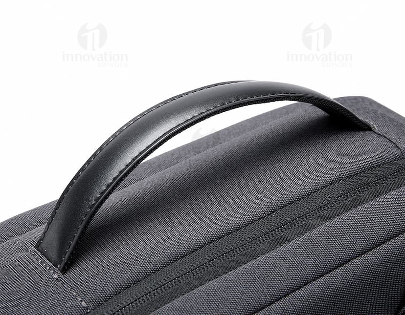 Mochila para Notebook Premium em material metalizado preto, com textura moderna e detalhes em prata. Possui diversos compartimentos e suporte acolchoado para laptop, fecho de zíper resistente e alças ajustáveis. Ideal para transporte seguro de equipamentos eletrônicos, como tablets e fones de ouvido.
