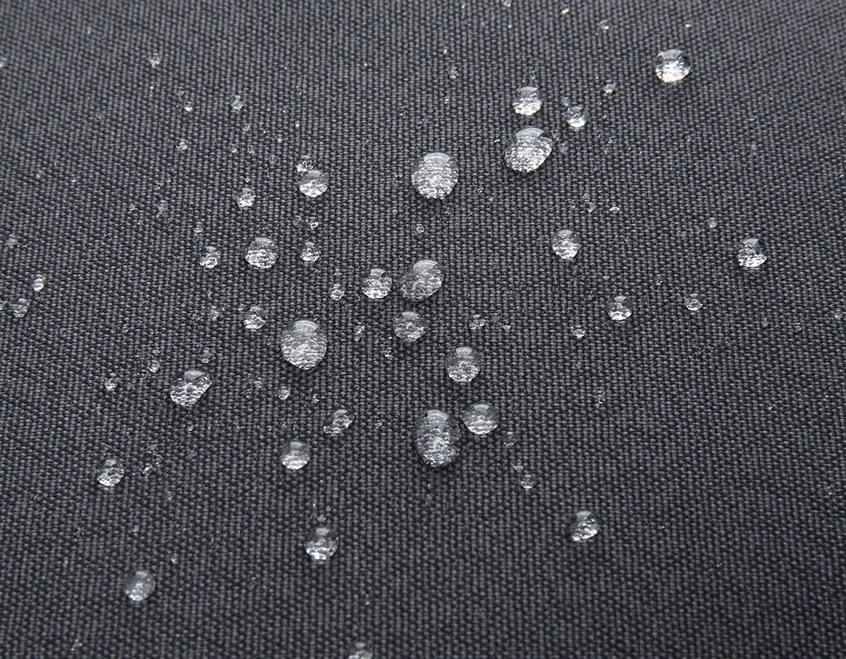 Mochila para Notebook Premium em textura de tecido de algodão preto com padrão de grade moderno e design decorativo. O fundo apresenta um padrão de tecido texturizado e reflexos de água, criando um visual industrial e futurista.