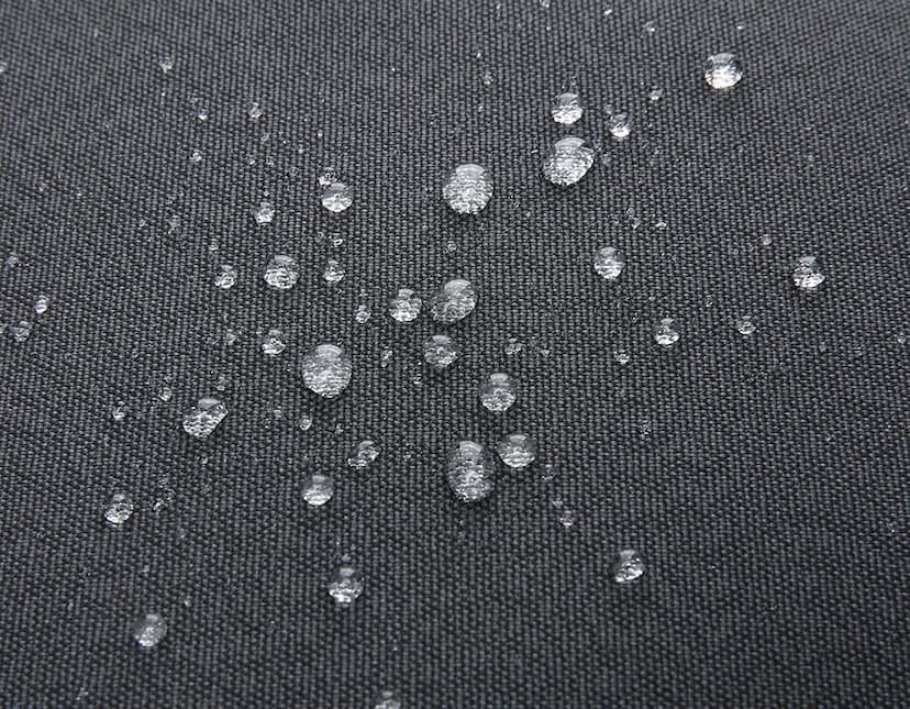 Mochila para Notebook Premium em textura de tecido de algodão preto com padrão de grade moderno e design decorativo. O fundo apresenta um padrão de tecido texturizado e reflexos de água, criando um visual industrial e futurista.