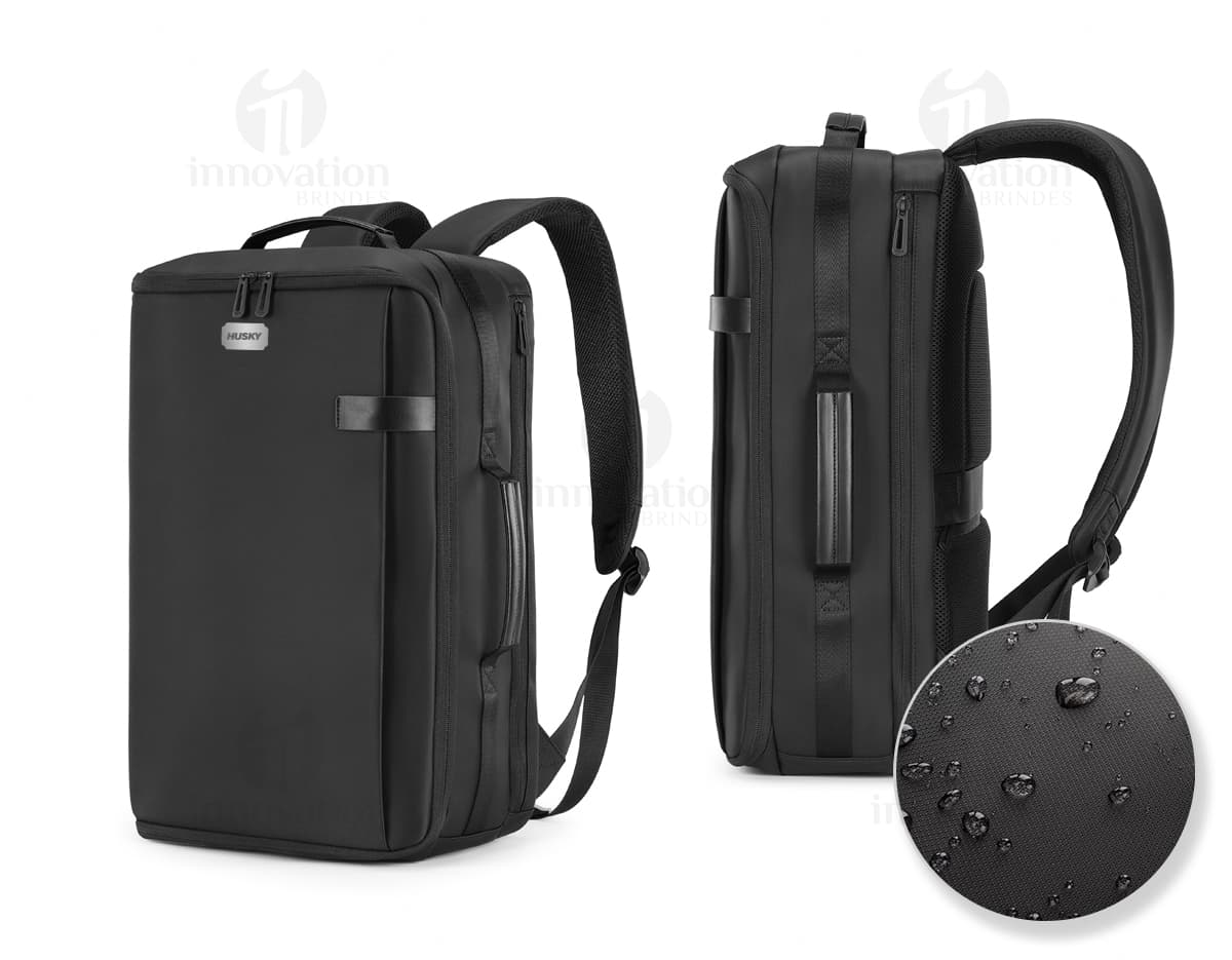 Mochila para Notebook Premium em couro preto, com compartimento para laptop e diversos equipamentos eletrônicos, como câmera, discos rígidos, caixa de som, headsets e outros acessórios. Design moderno, fecho seguro e alças confortáveis para viagens e uso profissional.