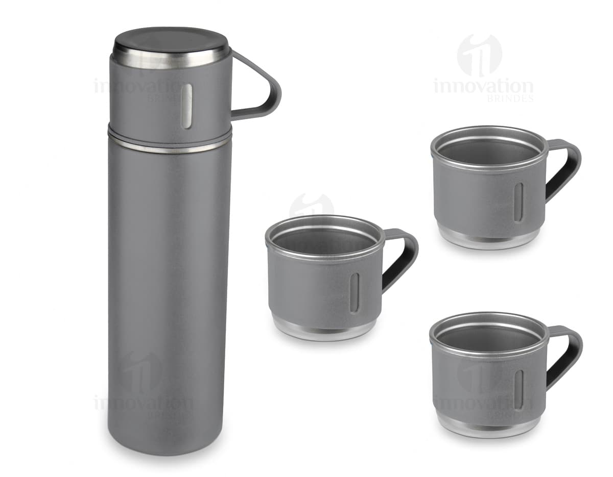 Garrafa térmica em aço inox com 3 copos sobre uma superfície de madeira escura.