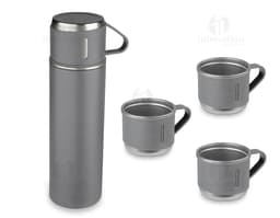 Garrafa térmica em aço inox com 3 copos sobre uma superfície de madeira escura.