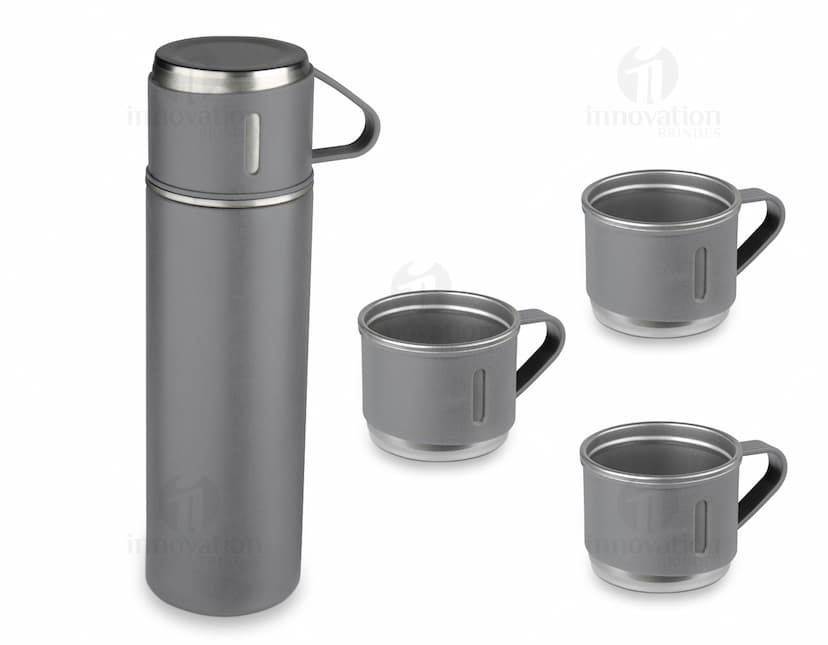 Garrafa térmica em aço inox com 3 copos sobre uma superfície de madeira escura.