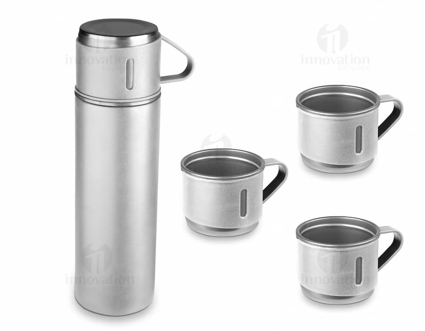Garrafa térmica em aço inox com 3 copos sobre uma superfície de madeira escura.