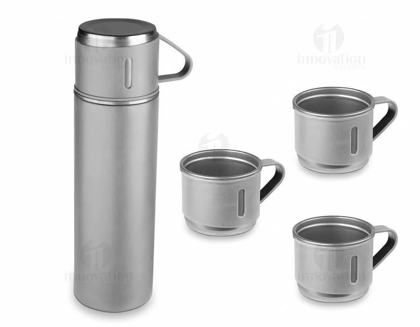Garrafa térmica em aço inox com 3 copos sobre uma superfície de madeira escura.