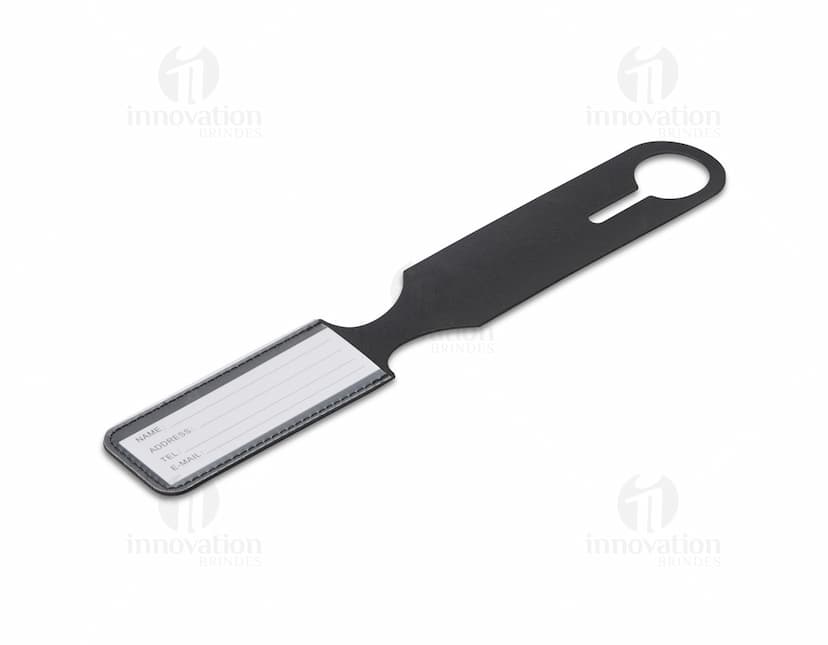 Identificador de Bagagem em metal prateado, com alça preta e plástico transparente para inserir informações. Item útil para identificar malas durante viagens.