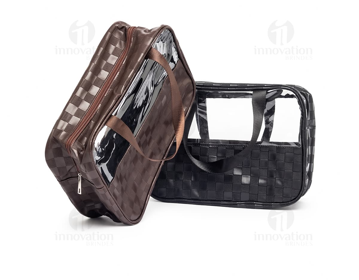 Necessaire PVC impermeável em cor preta e marrom, com alça de couro, fivela de metal e zíper. Acessório de moda elegante e moderno para transportar itens pessoais com estilo e praticidade.