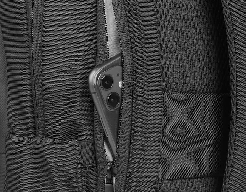 Mochila preta de couro com detalhes em metal prateado, fecho de zíper, bolsos e compartimentos para notebook e outros equipamentos eletrônicos. Modelo moderno e elegante, ideal para profissionais de negócios ou estudantes que precisam transportar seus dispositivos com segurança e estilo.