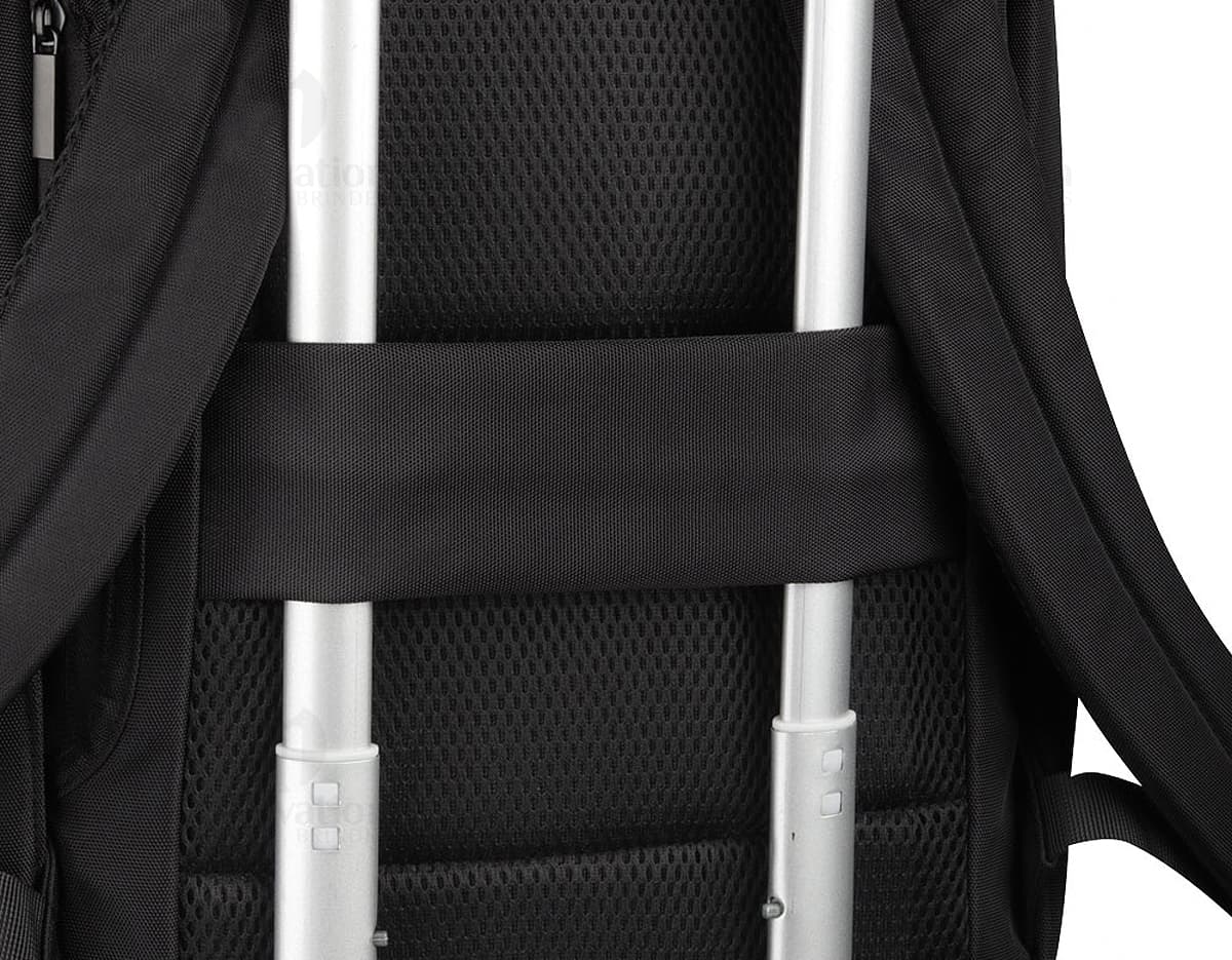 Mochila para notebook preta, moderna e elegante, sendo segurada por um homem de negócios em um escritório. O homem está sentado em uma cadeira de escritório com apoio para braços, ao lado de uma mulher com uma mochila e um laptop. Ambos vestem roupas corporativas. A imagem mostra detalhes como o dispositivo eletrônico na mochila e a moderna arquitetura do interior do escritório.