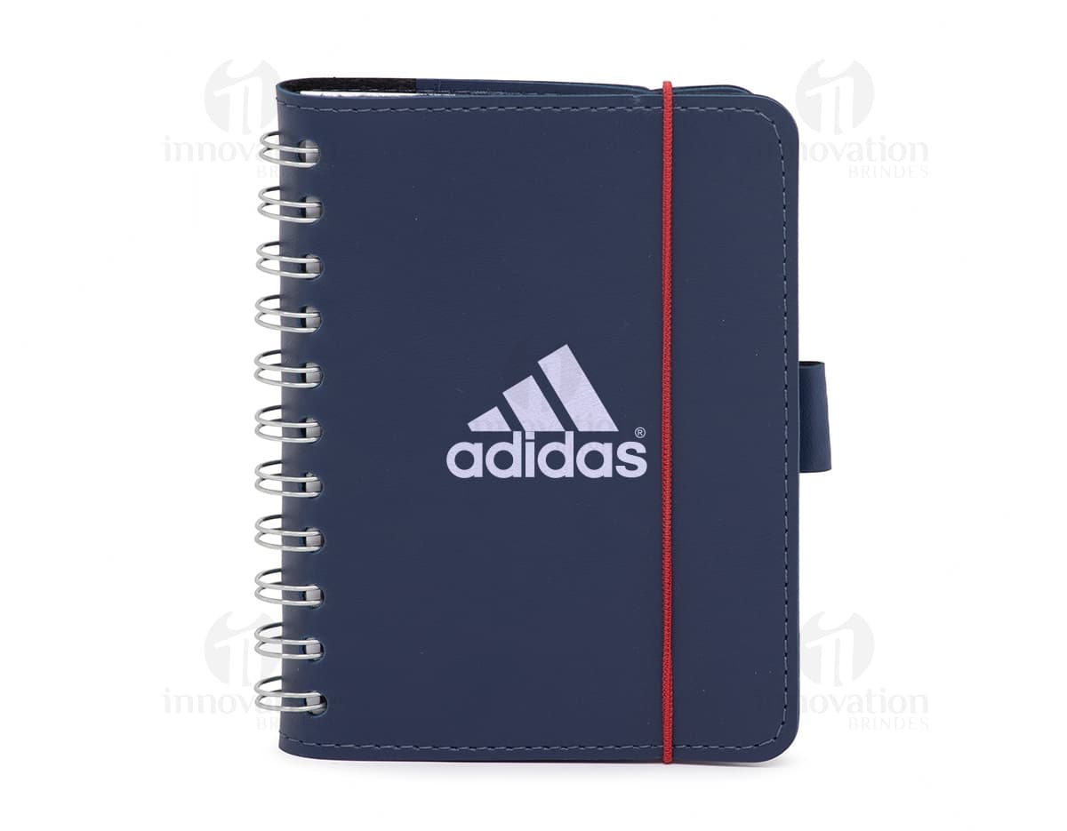 Notebook de couro sintético em branco com capa protetora, utilizado para anotações e organização de documentos no escritório. O design moderno e elegante proporciona espaço para escrita e armazenamento de informações importantes. Ideal para uso em reuniões, estudos e trabalho, mantendo tudo organizado e protegido.