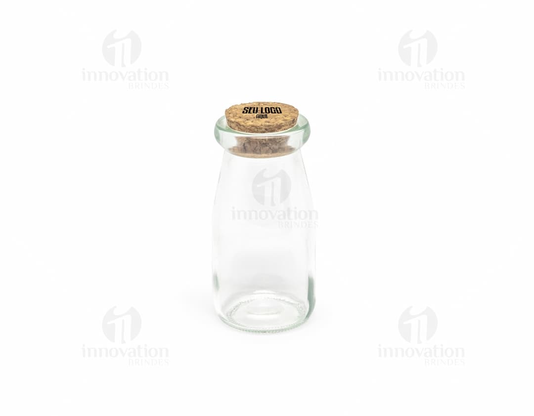 Frasco de vidro transparente de 100ml com tampa de metal, vazio e com rótulo em branco. O frasco pode ser usado para armazenar líquidos como água, leite, remédios ou produtos cosméticos. Ideal para manter a saúde e higiene, mantendo os produtos frescos e puros.
