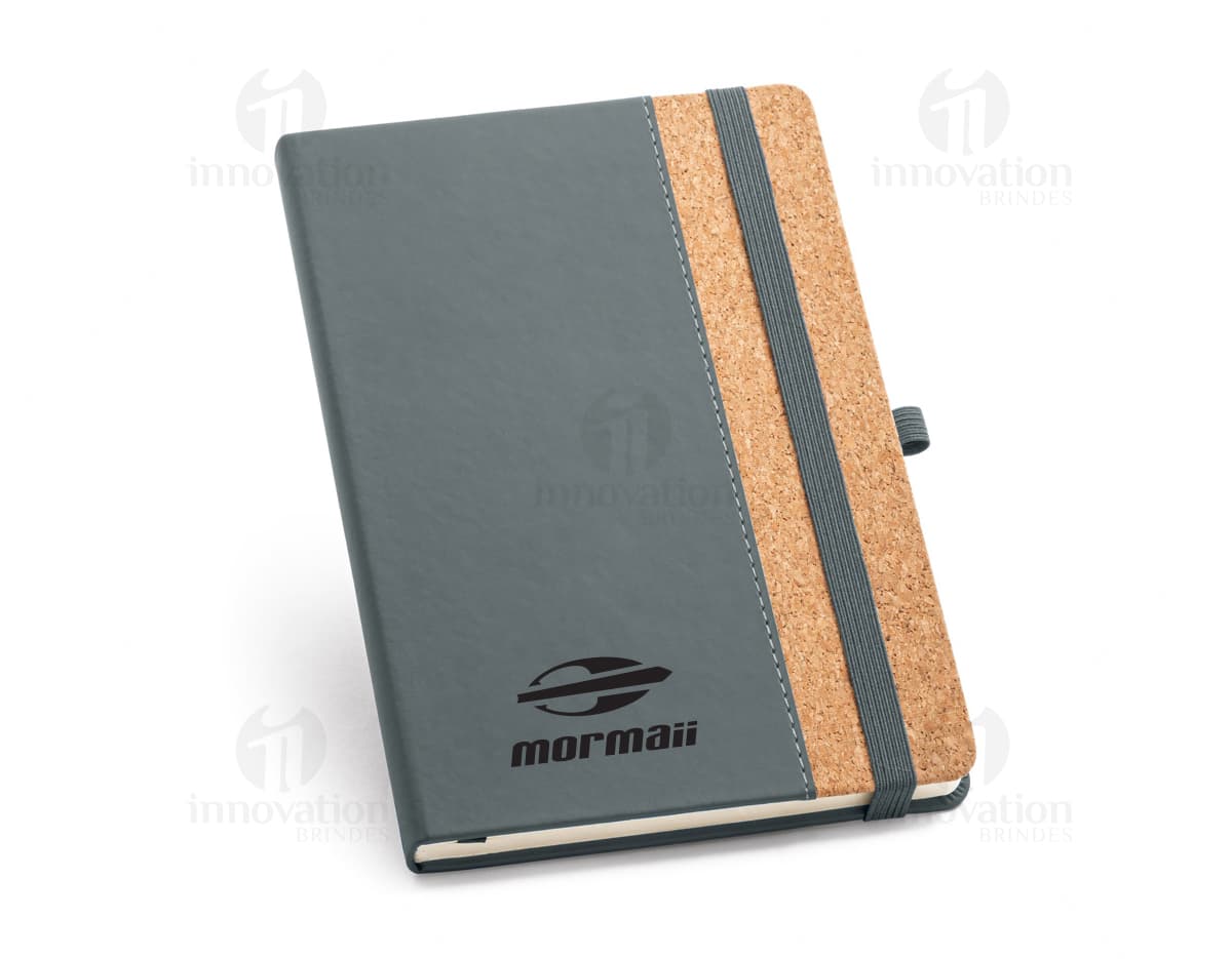 Notebook em cortiça A5 com capa dura em estilo vintage, perfeito para uso educacional, profissional ou pessoal. Possui páginas em branco, ideal para fazer anotações, lembretes, ou até mesmo jogar poker. Este caderno é um símbolo de organização e estilo, trazendo um toque de nostalgia e elegância para o seu escritório ou escola.