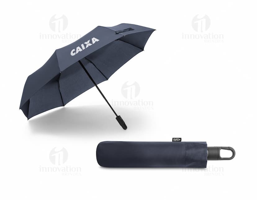 Guarda-chuva dobrável preto em formato de capelo de formatura, simbolizando sucesso e educação. O objeto 3D está aberto e vazio, sendo segurado por uma mão masculina. A imagem representa conhecimento, celebração e conquista acadêmica.