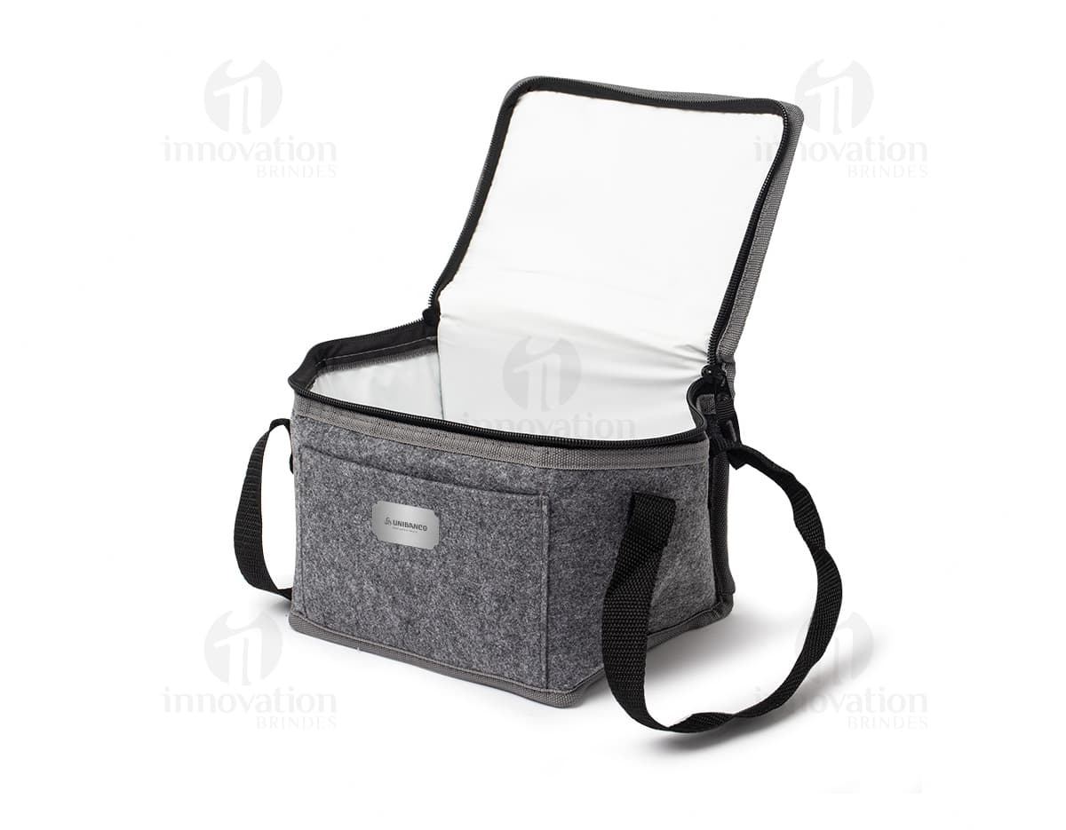 Bolsa térmica de 5 litros em um ambiente doméstico, próximo a uma torradeira e outros utensílios de cozinha. A bolsa está vazia, feita de material durável e em tom de marrom, com detalhes em metal.