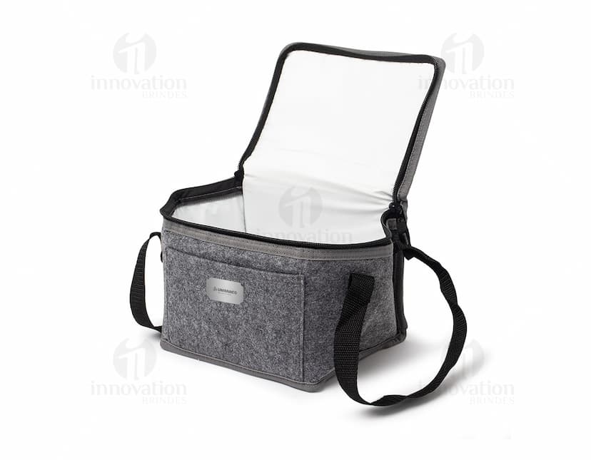 Bolsa térmica de 5 litros em um ambiente doméstico, próximo a uma torradeira e outros utensílios de cozinha. A bolsa está vazia, feita de material durável e em tom de marrom, com detalhes em metal.