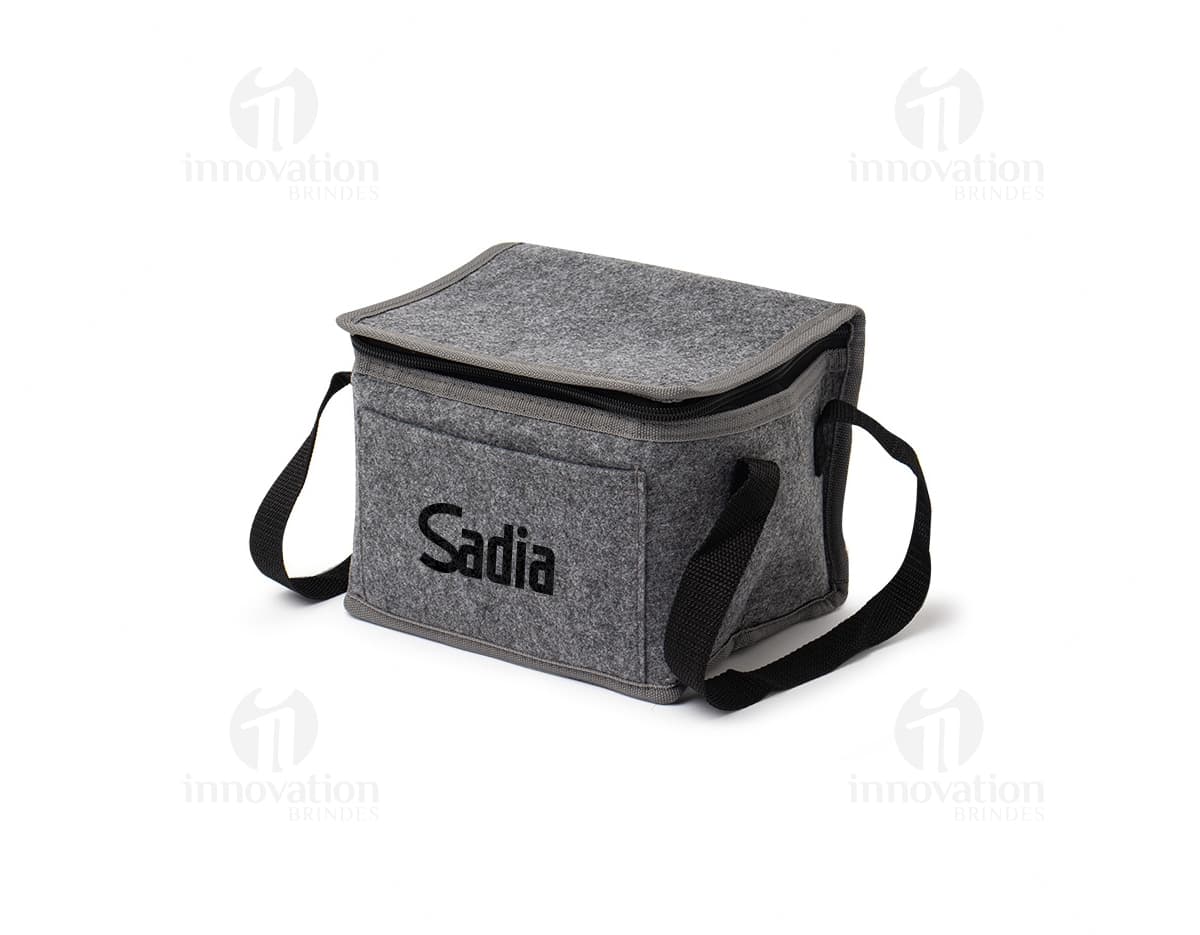 Bolsa térmica de 5 litros em um ambiente doméstico, próximo a uma torradeira e outros utensílios de cozinha. A bolsa está vazia, feita de material durável e em tom de marrom, com detalhes em metal.