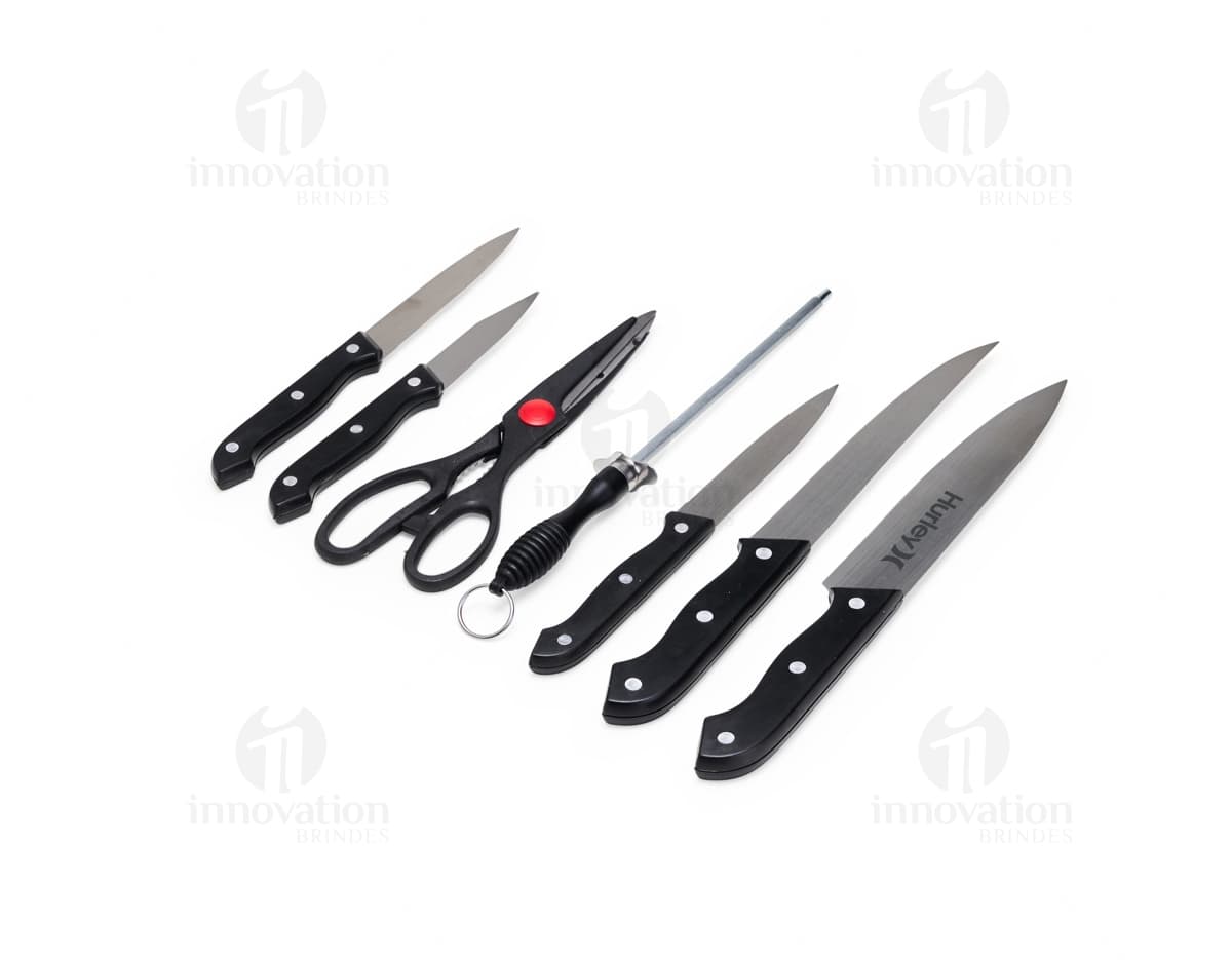 Kit churrasco de 7 peças em aço inoxidável, incluindo faca, garfo, pinça, espátula, escova de limpeza, amolador e maleta preta. Ideal para o amante de churrasco que busca qualidade e praticidade em suas ferramentas.