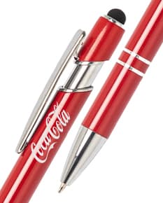 Caneta metal touch em diversas cores sobre uma mesa de escritório, ao lado de um bloco de notas, lápis e papel.