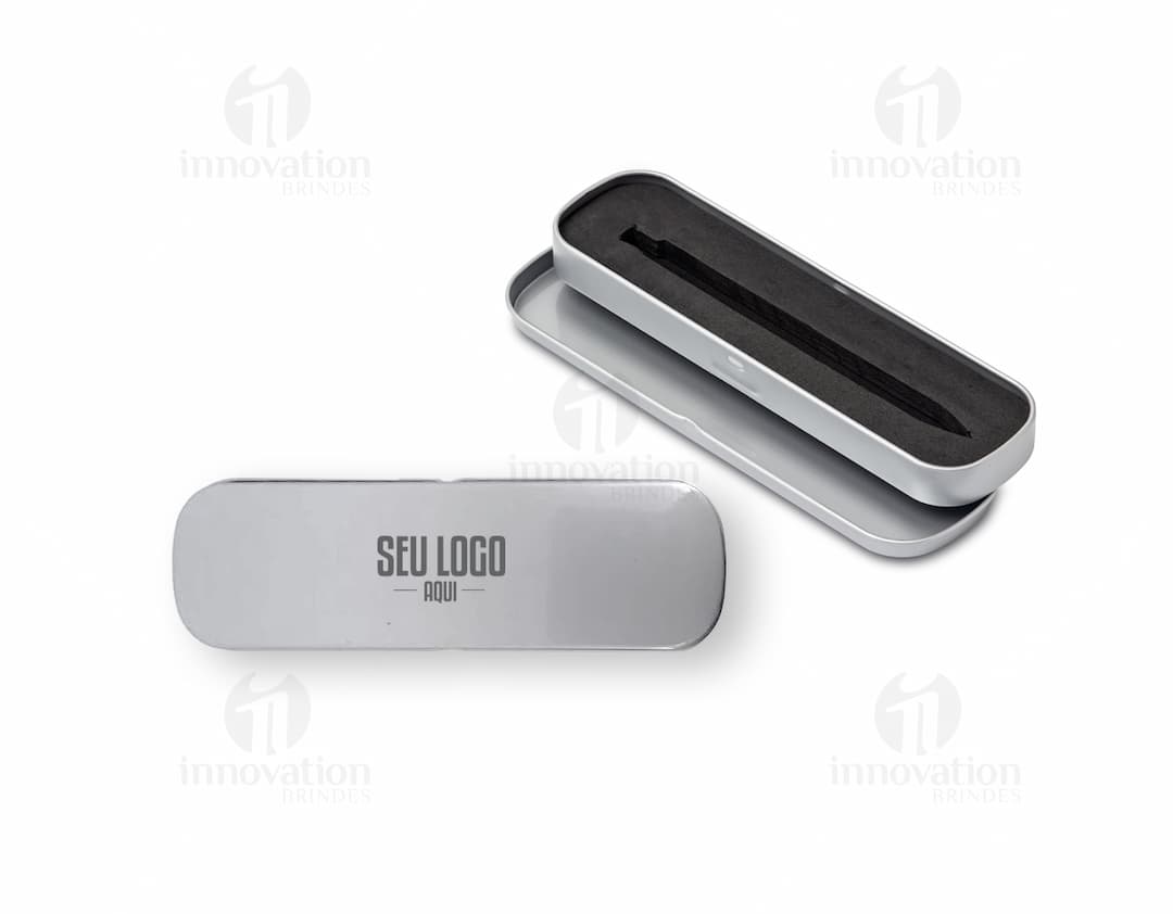 Estojo de metal preto vazio, com design moderno e prateado. Na imagem, há também uma caneta, uma chave de computador, um modem, um pen drive e um ferro de passar. O estojo contém ainda um grampeador, um modem, um drive de armazenamento e um botão preto.